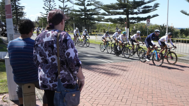 A couple watch as cyclists train ahead of the world road cycling championships in Wollongong.