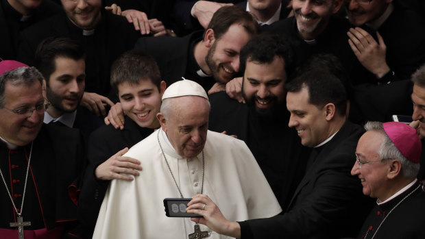 Pope Francis poses for a photo with a group of priests at the end of his weekly general audience on Wednesday.