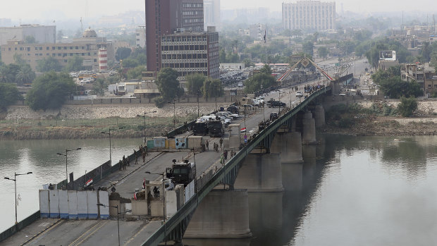 Security forces fire tear gas and close the bridge leading to the Green Zone during a demonstration in Baghdad, Iraq.