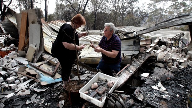 Phil and Sue Dunlop search for valuables in the remains of their home in Winmalee in the Blue Mountains in 2013. 