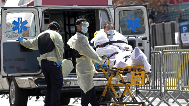 A patient is wheeled out of Elmhurst Hospital Center to a waiting ambulance.