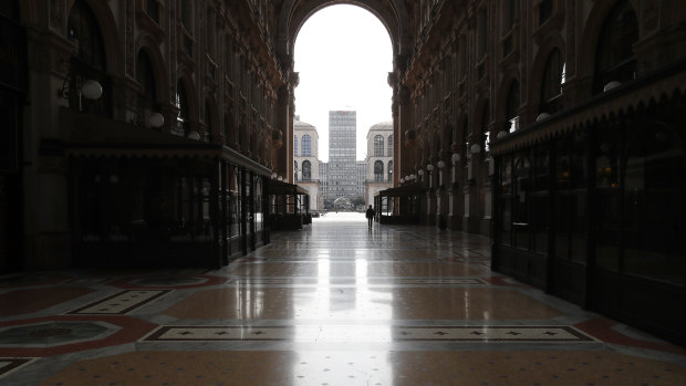 A woman walks in the empty Vittorio Emanuele II gallery shopping arcade in downtown Milan, Italy.