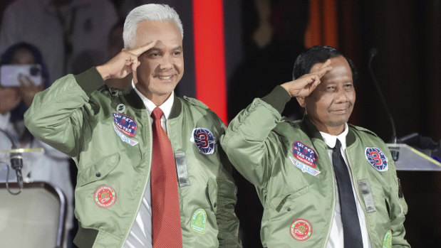 Ganjar Pranow (left) and his running mate Mahfud MD arrive at a televised debate this month.