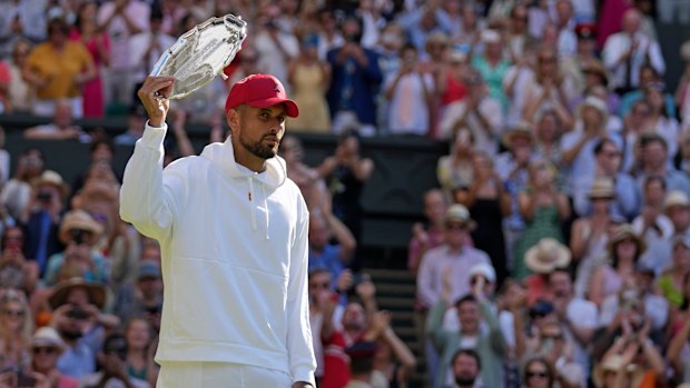 Nick Kyrgios, sporting a red cap, with the runner up trophy.