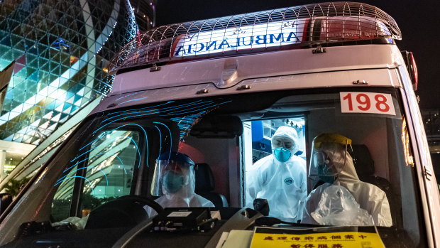 An ambulance stops outside the Grand Lisboa Hotel in Macau, where casinos will close for two weeks.