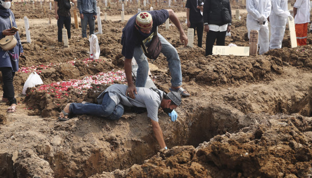 A man grieves during the burial of a relative at Jakarta’s Rorotan cemetery. 