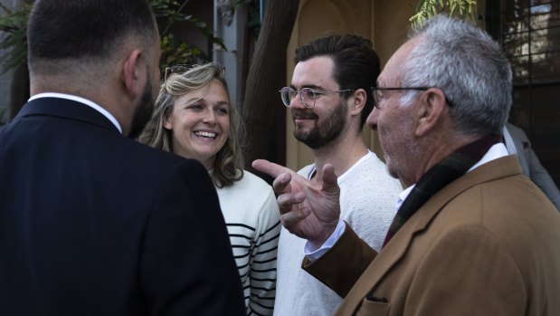 The owner congratulates the successful first-home buyers.