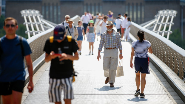 Pedestrians cross London’s Millennium Bridge on so-called Freedom Day.