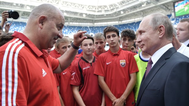 Russian President Vladimir Putin listens to Russia's head coach Stanislav Cherchesov as he visits the Kaliningrad Stadium after the 2018 World Cup.