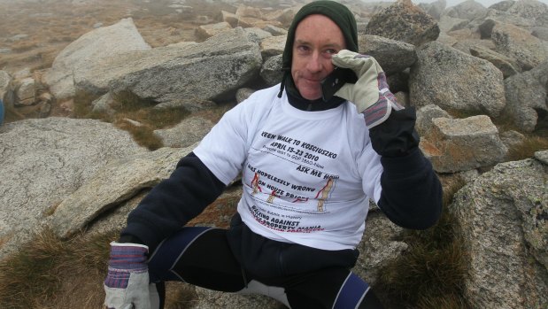 Economist Professor Steve Keen reaches the summit of Mount Kosciuszko to complete his walking journey from Canberra as part of a bet he lost after predicting house prices would decline.