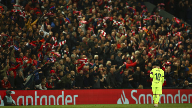 Lionel Messi walks in front of jubilant Liverpool fans after Liverpool scored their fourth goal.