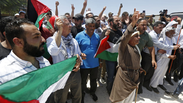 Palestinians hold flags during a protest in Khan al-Ahmar, last week. 