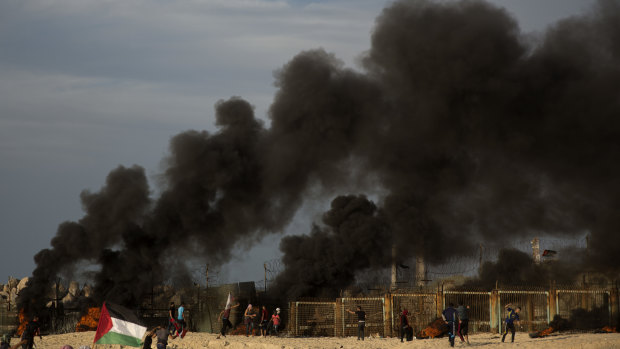 Palestinian protesters burn tires next to the border fence during a protest on the beach at the border with Israel near Beit Lahiya, northern Gaza, On Monday.