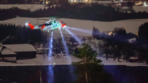 A person is lowered from a rescue helicopter near the site where the landslide hit a residential area in Norway.