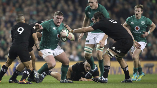 Ireland's Tadhg Furlong is tackled by New Zealand's Sam Whitelock and Aaron Smith (left).