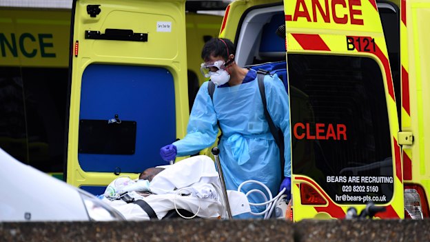 A patient is taken from an ambulance outside St Thomas' Hospital in London.