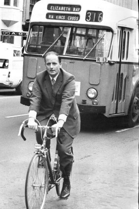 Transport Minister Milton Morris rides a bicycle from his office in Macquarie Street to a rally in Hyde Park North, 1974.