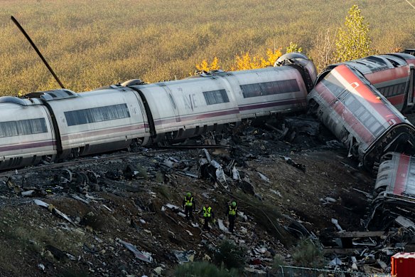 Security forces work at the scene of a train crash on Thursday.