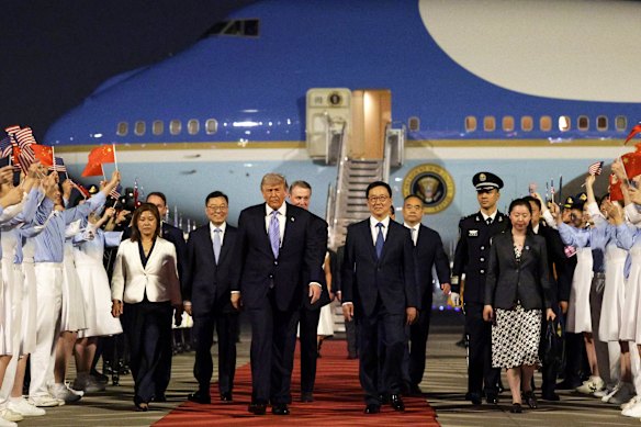 Il presidente degli Stati Uniti Donald Trump viene accolto da giovani cinesi, da una guardia d'onore militare e da una banda militare quando arriva mercoledì all'aeroporto internazionale di Pechino.