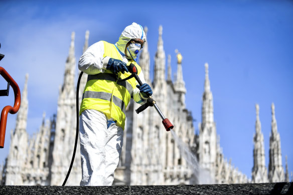 A worker sprays disinfectant to sanitise Duomo square in Milan.