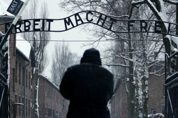 A visitor walks under the German inscription that reads "Arbeit Macht Frei" ("Work makes you free") at the main gate at the Auschwitz concentration camp in Poland.