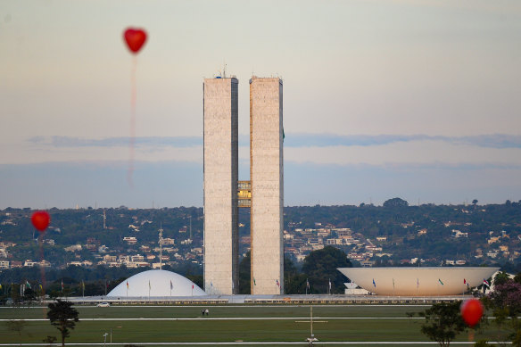 Artists from Brasilia hold a performance with red balloons in honour of victims of coronavirus outside the Brazilian Senate and Congress on Monday.