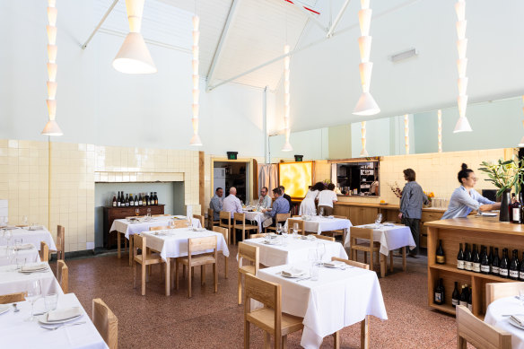 The dining room is high-ceilinged, strung with ceramic lights as delicate as paper.