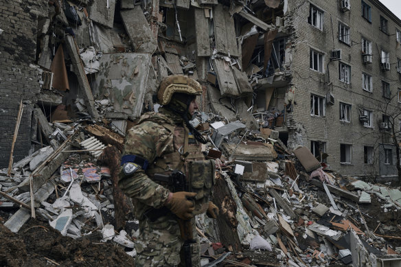 A Ukrainian soldier inspects a damaged apartment building in war-hit Avdiivka in the Donetsk region on April 12.