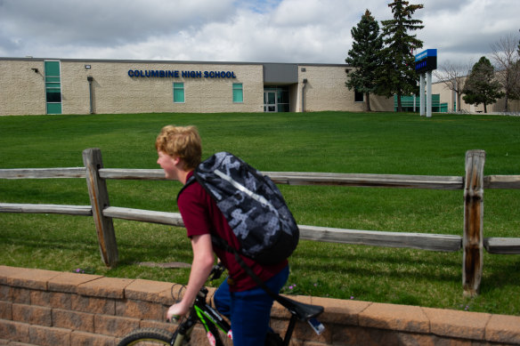 A student bikes past Columbine High School.