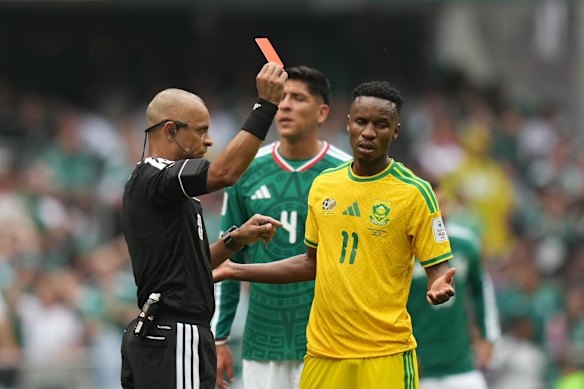 Referee Wilton Sampaio of Brazil shows a red card to South Africa’s Themba Zwane in the match against Mexico.