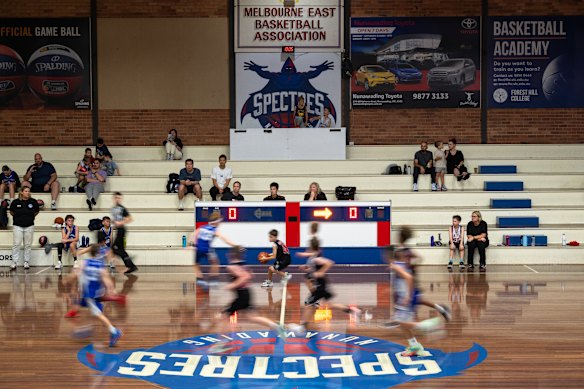 The old stands on court one at Nunawading Stadium, opened in 1969, as kids play Saturday morning basketball.