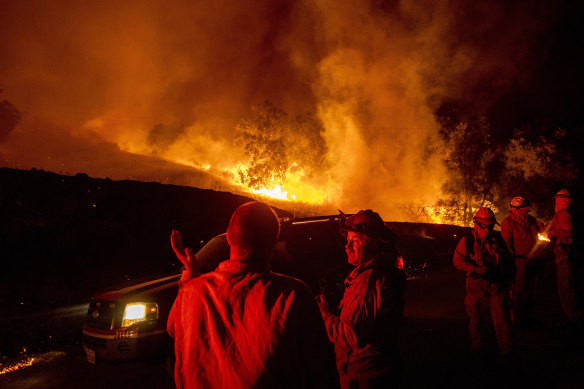 Firefighters confer while battling the Kincade Fire near Geyserville, California.