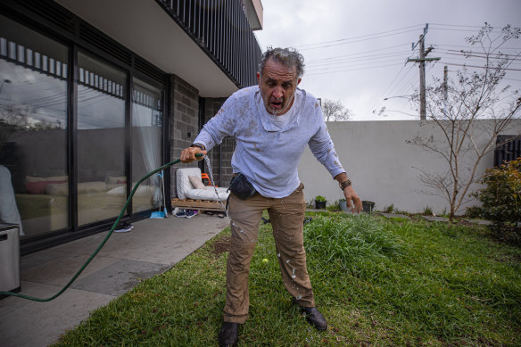 Luis Ascui washes his eyes out with water from a garden hose after being spray with OC foam.