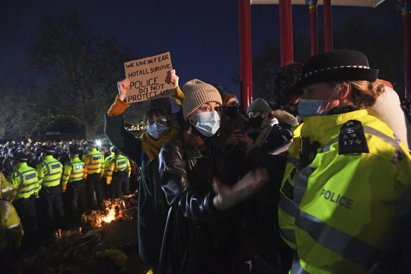 A woman reacts in Clapham Common, as people gather despite the Reclaim These Streets vigil for Sarah Everard being officially cancelled, in London.