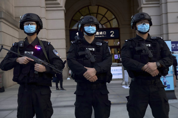 Riot police officers stand guard outside Hankou train station ahead of the resumption of train services in Wuhan on Wednesday.