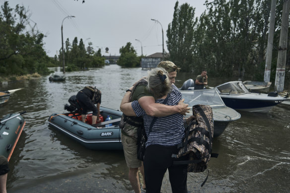 A woman hugs a volunteer who helped her to get evacuated on a rubber boat from a flooded neighbourhood in Kherson, Ukraine.
