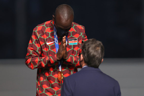 Eliud Kipchoge of Kenya thanks the IOC official who presented him the gold medal.