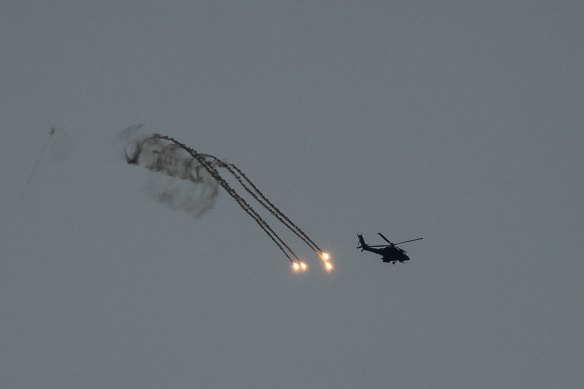 Israeli helicopter fires flares near the border with Gaza on December 29 in Southern Israel.