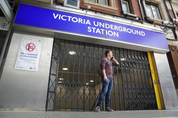 A person stands outside a closed Victoria underground station in central London on August 19. Tube, rail and bus services are set to be severely disrupted in the capital as members of Unite and the Rail, Maritime and Transport (RMT) union strike in a continuing row over pay, jobs and conditions. 