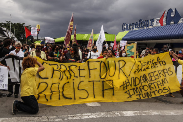 Demonstrators hold banners and signs in front of the entrance to the Carrefour Niteroi-Manilha branch as protests erupt against racism in Brazil.