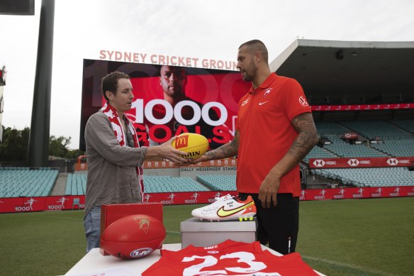 Alex Wheeler returns the 1000th goal game ball to Buddy Franklin.