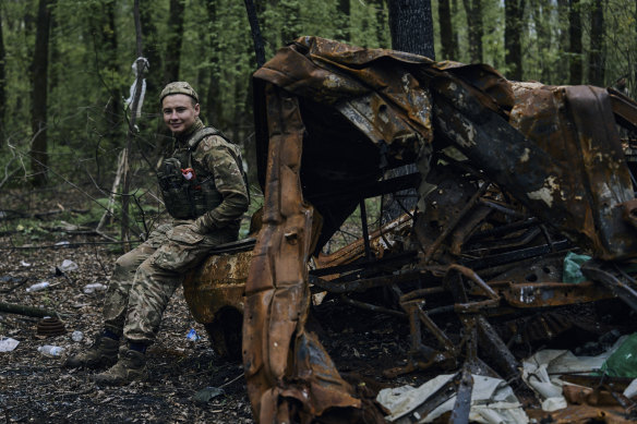 A Ukrainian soldier rests on a burned vehicle on the frontline in Bakhmut, Donetsk region, on Sunday, April 23.