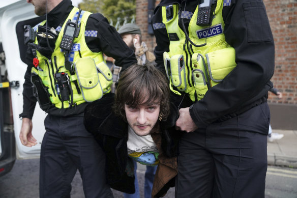 Police detain a protester after he appeared to throw eggs at King Charles.