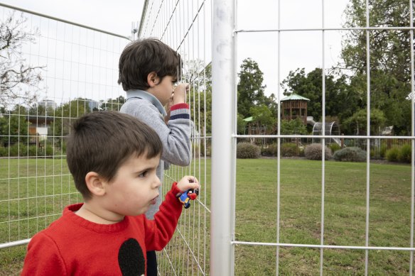 Taylan, 9, and Izzay, 4, outside the closed Footscray Park playground.