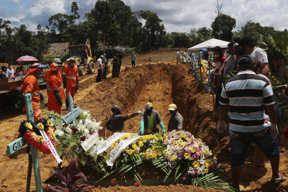Workers prepare a pit for a mass burial at a cemetery in Manaus, Brazil.