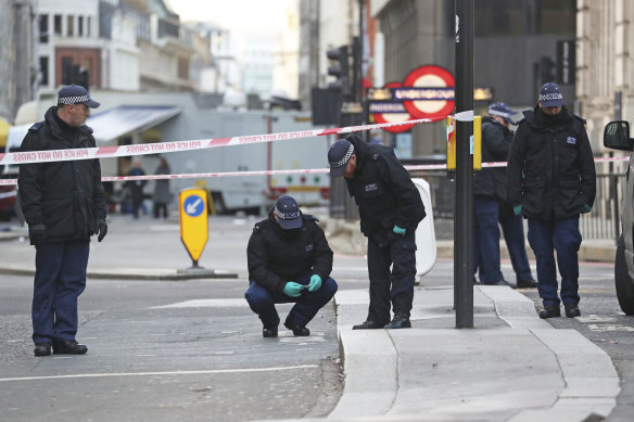 Police officers investigate the scene of the attacks in central London on Saturday.