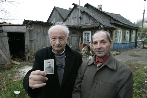 Alex Kurzem (left) with Erik Galperin in front of the Galperin family’s pre-war house in Belarus in 2007. Kurzem, holding a photo of Erik’s father Solomon, believed he and Erik were half-brothers.