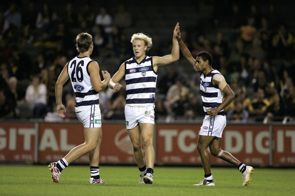 Hawkins and Varcoe celebrate with Nathlan Ablett after his goal.