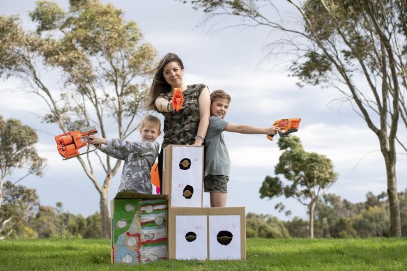 Stavrelle Giourousis and her daughters Georgie, 8, and Delphi, 5, with their homemade targets and Nerf guns.