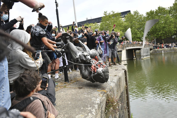 Protesters throw a statue of slave trader Edward Colston into Bristol harbour.